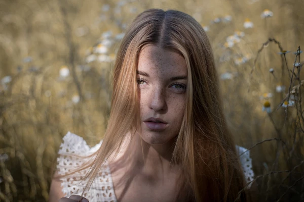 This is a picture of my series ´summer freckles´. A play of light and shadow in the face of the model created this natural portrait on a meadow.