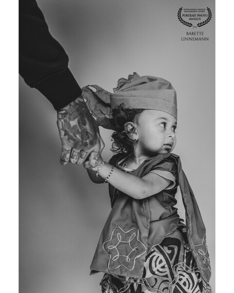 This is a special photo for me that I value very much. The shoot is with my daughter Noï in her cultural clothing from Surinam called "kotomisi". The spontaneous photo with her father's helping hand, which also contains many details, is the protective hand in her life. That's why it's an honor for me to receive an award for this photo.
