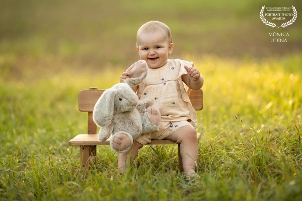 Júlia, 9 months, in the park with her stuffed rabbit.