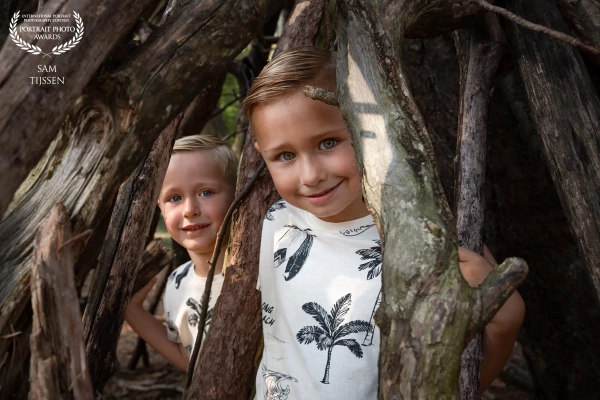 Spelende broertjes tijdens een gezinshoot in het bos.