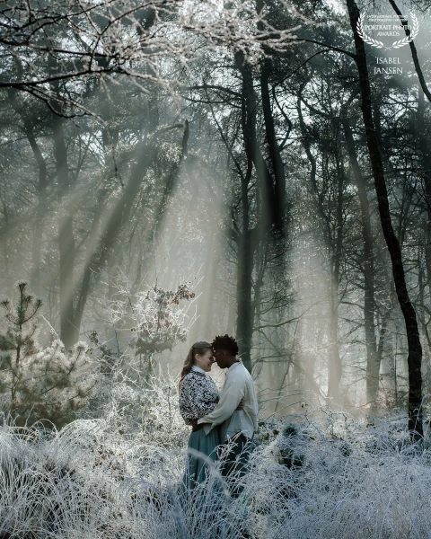 In a frost-kissed forest, where winter’s breath lingers on every branch, two souls find warmth in ea...