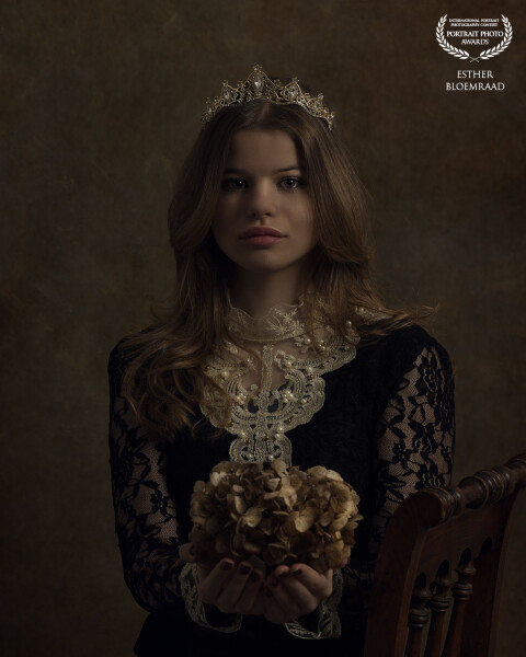 For the shoot with Lieke, I used dried hydrangea flowers from my garden. Tiny spiders emerged from the flowers, which she didn’t particularly enjoy, yet she kept her gaze beautifully steady in front of the camera. With the elegant crown on her head, the result is a regal portrait.<br />
<br />
Model: Lieke<br />
Photo & edit: @estherbloemraad.fotografie