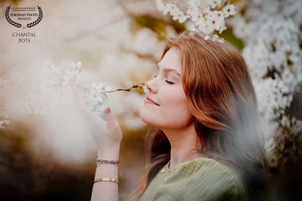'Where blossoms bloom and her hair catches the wind — beauty grows untamed.'