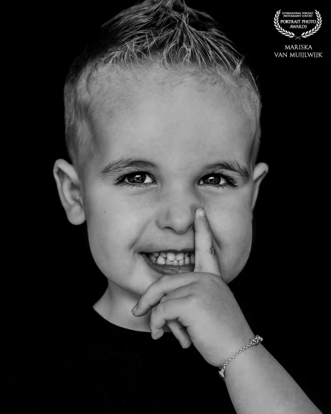 A straightforward portrait of a young boy, facing the camera. Neutral in tone, with attention to light, contrast and natural features.