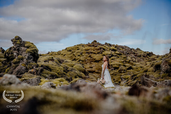 A bride standing in the heart of Iceland’s moss-covered lava fields — a quiet moment where wild natu...