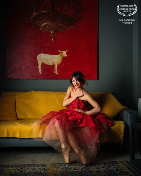 A beautiful woman sits relaxed on an elegant sofa, the light highlighting her delicate features and...