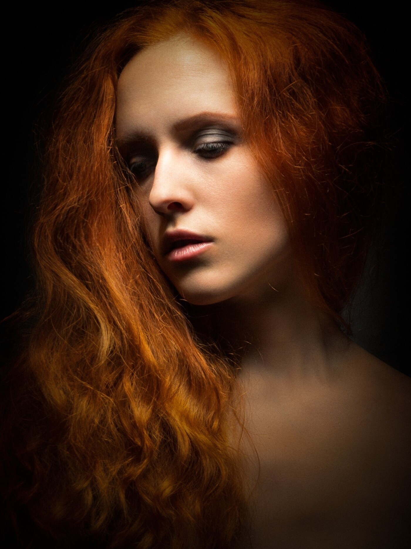 For this picture I experimented a lot with the light. At first I wanted the light to be very tight and close around the face, so I put the spot only on her face. But when I saw how beautiful and stunning the red hair looked, I changed that idea. When I look at the final result I’m very glad, I didn’t stick to that initial idea and stayed flexible in the process.