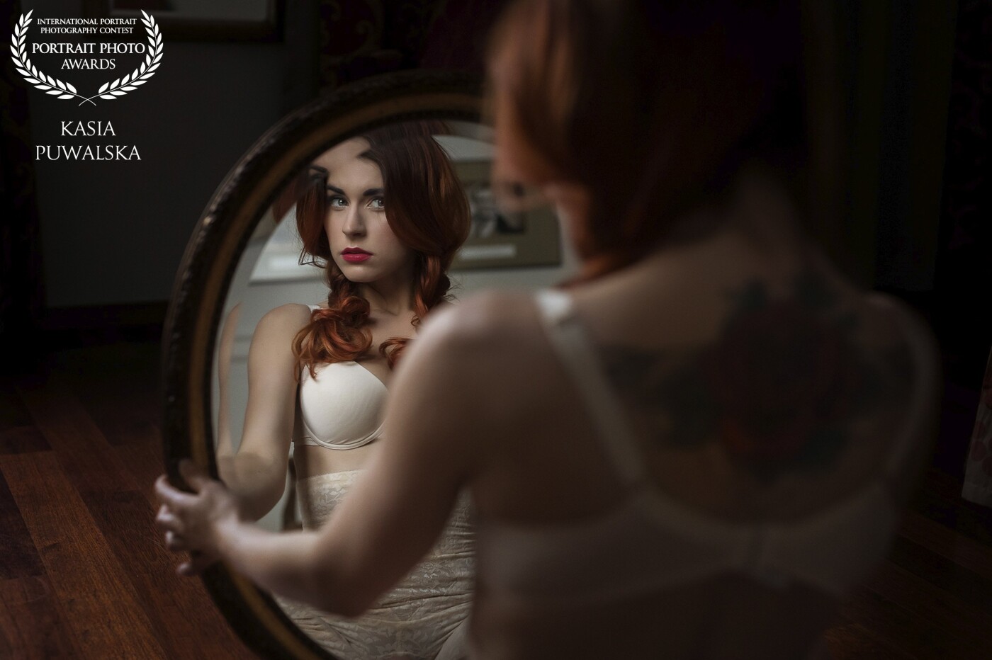 A portrait of beautiful red hair polish girl and her reflection in a mirror in natural light.