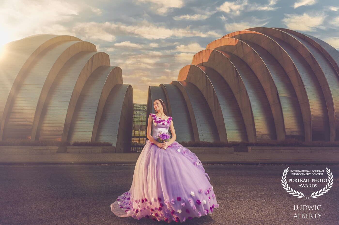 This is a quinceañera photoshoot, quinceañera is the sweet sixteen in Latin America, we chose the Kauffman center for the performing arts as a background because of the impressive architecture of the building. We went early in the morning for 2 reasons, 1. To avoid crowds and 2. Take advantage of the golden hour. I think the beautiful dress is a perfect contrast with the background. Love how the photo came out and the opportunity that Mother Nature gave me that day for this photo.