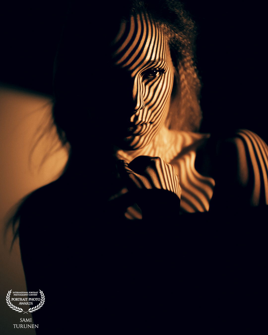 This photo is part of my creative lighting setup where I use projection to create gobo portrait. Stripe gobo gives nice shapes and flows through model's (awesome Emma Luukkanen) natural curves. In this frame I used black silhoutte against bright background to create a dimension. Definitely one of my favs in this set.