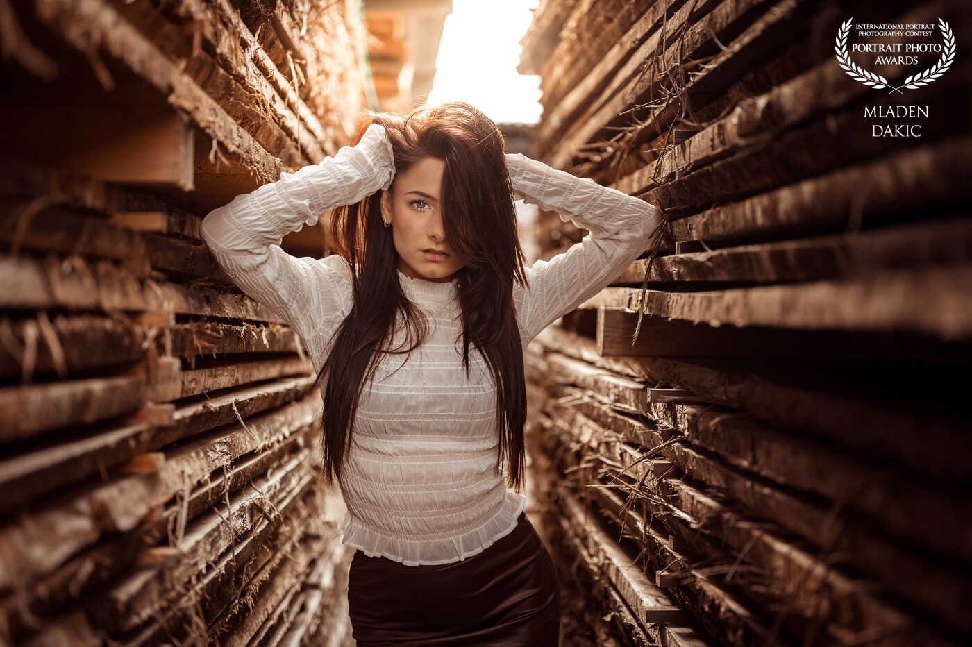 This photo of my model Lina (linaexp on IG) is the result of a great photo shooting day. I saw this sawmill with the stacks of wooden planks and spontaneously decided that this location we should use for the finish of the day. <br />
One set we made there ist this one in between these wooden plank stacks where I shoot the model against the evening sun. I named the picture "Wooden Perspectives".<br />
<br />
I used natural light only.
