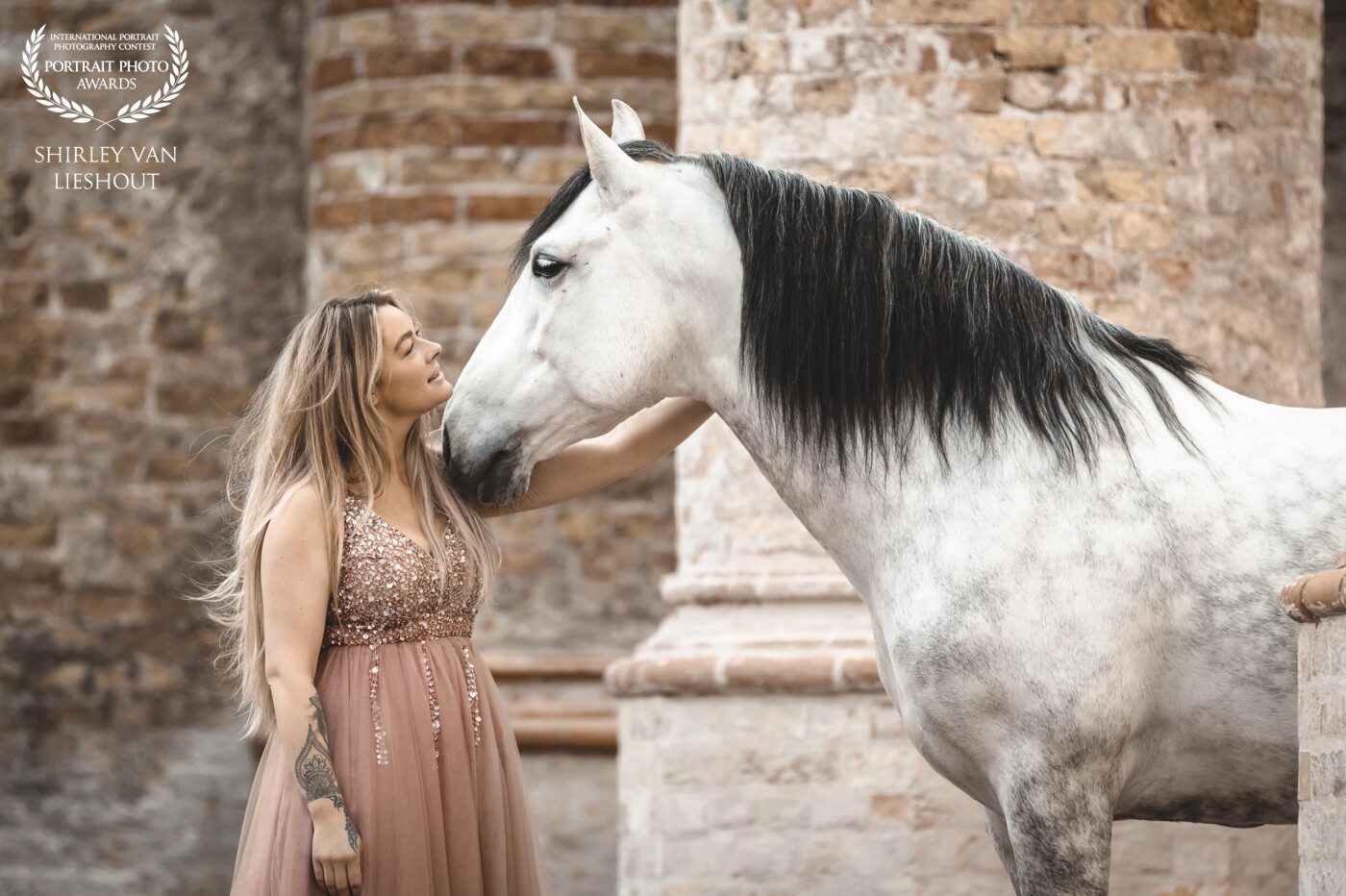 What a lovely couple they are together: Eline with her Andalusian stallion Trajé. This photo was taken during a portfolio shoot in a beautiful old church (Broerekerk) in Bolsward the Netherlands. And although it was very cold she stood there in that beautiful dress.