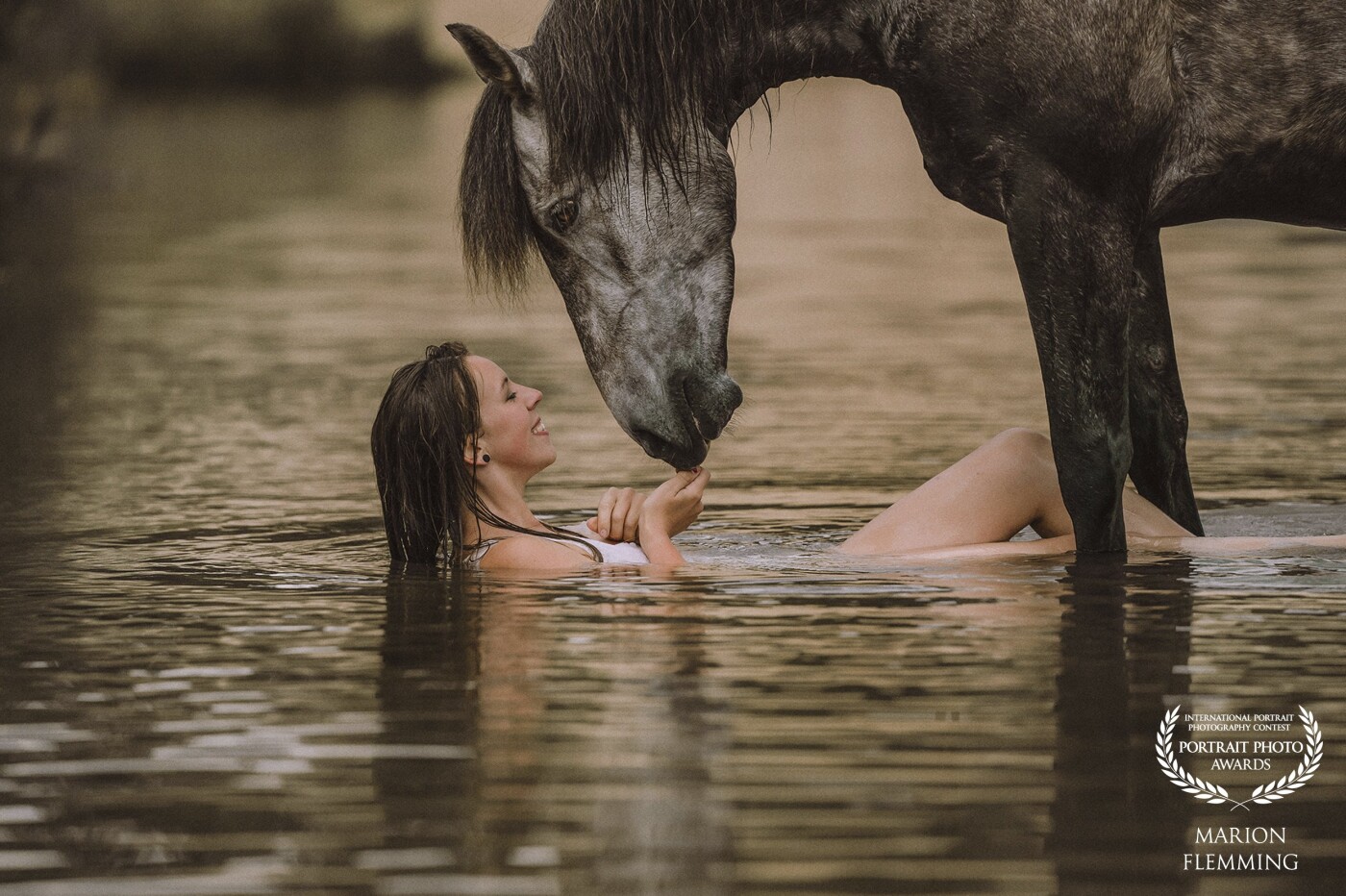 Janine and her wonderful spanish horse "Choclate".  Choclate is like a dog, he follow Janine everywhere and know a lot of tricks. Janine and Choclate are often goes swimming into this lake.  I took this photo with my Sony A9II and the 70-200 mm F2.8. during a warm summer evening.