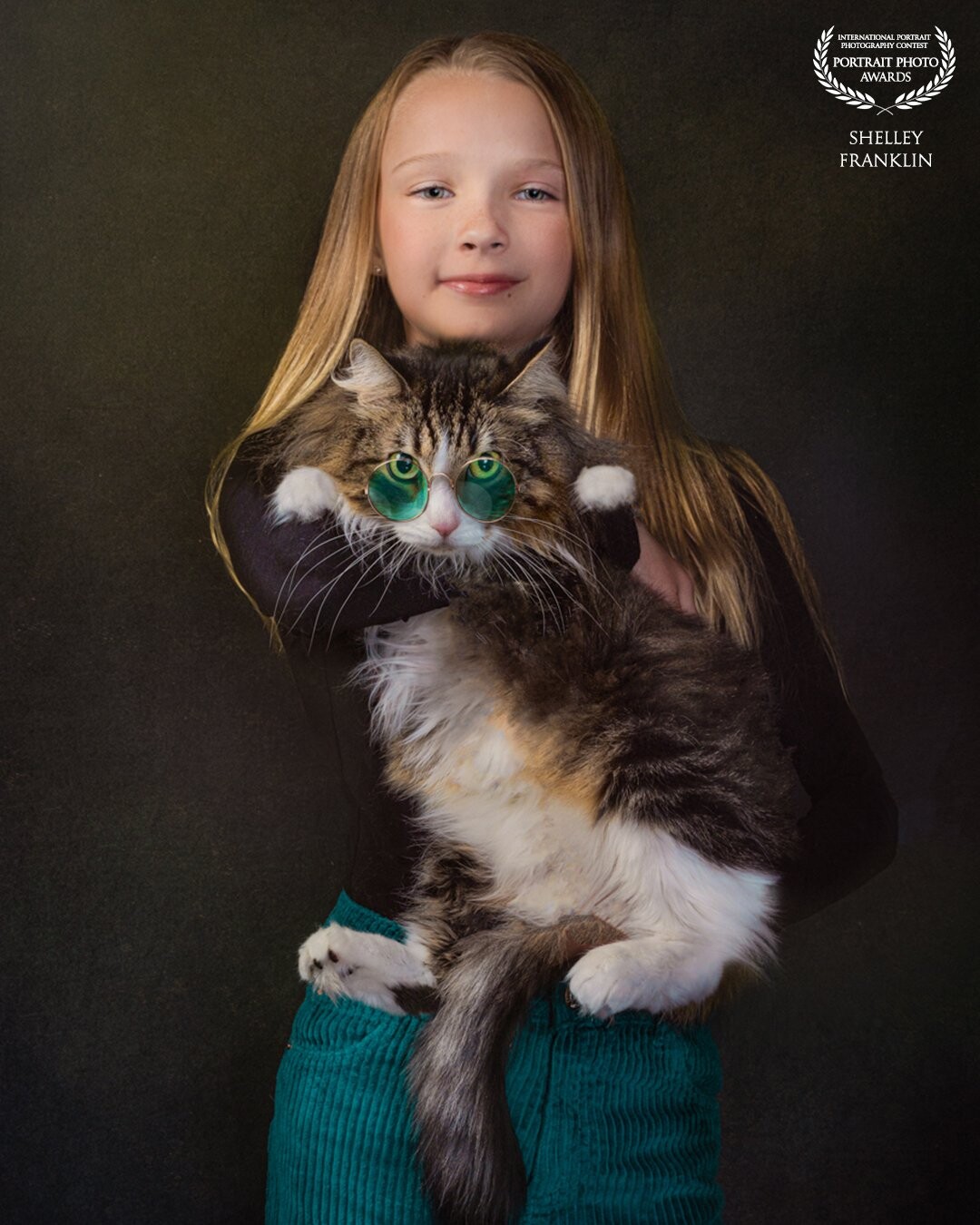 Shot in studio with a canon r5 and profoto d1’s. This little girl rescued her cat Skittles and they have a close bond. The little girls favorite color was the color of her pants so I thought it would be fun to give Skittles glasses that sort  of matched.  She looked very smart in them I think!