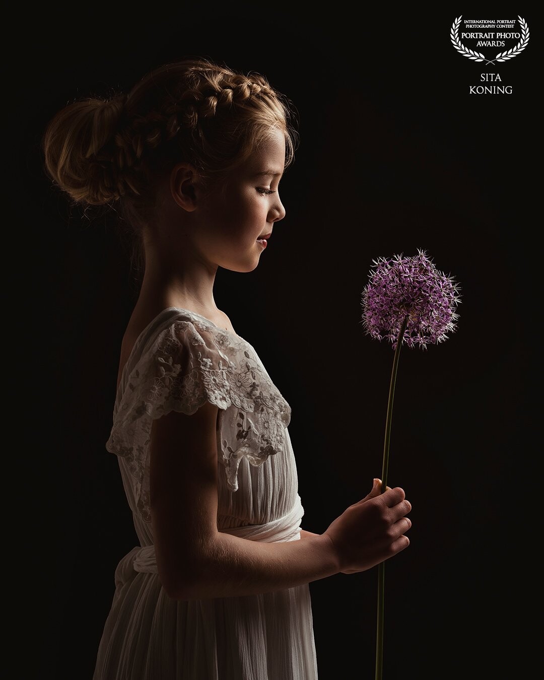 She comes to my studio every year around her birthday! Every time we try different poses and settings. In her beautiful white dress she holds a pretty flower. The settings of the light combined with the clothing and hairstyling makes this a very romantic picture