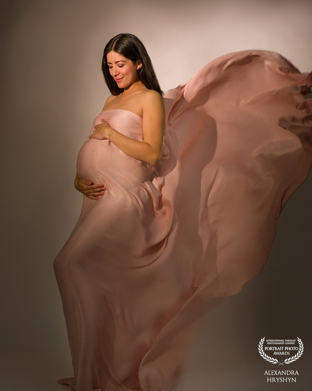 The precious moments of pregnancy. Maternity photo shoot with Material toss in Los Angeles photo studio.<br />
We chose light pink silk fabric and pastel color palette