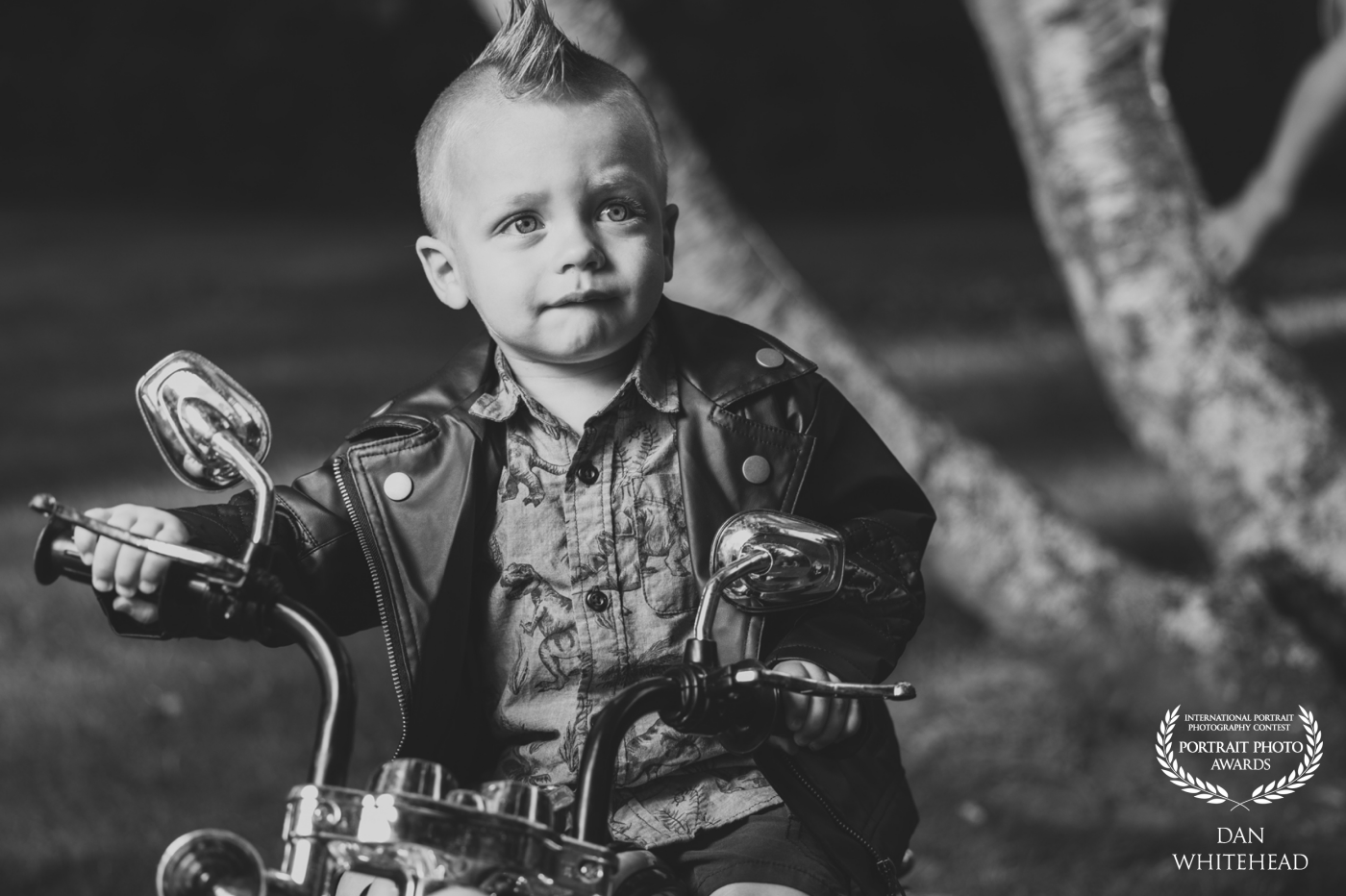 This is Logan. His parents asked me to capture some shots of him for his second birthday and really wanted to have  few on his motorcycle. We started the shoot with this look since it was the most “complex” and I placed my Westcott FJ200 to camera left with the standard reflector on it. He was somewhere between happy and upset when I took this shot, hence his mixed emotions. The flash really makes it seem darker in the day than it is. That wasn’t intentional, but it really works for black and white.