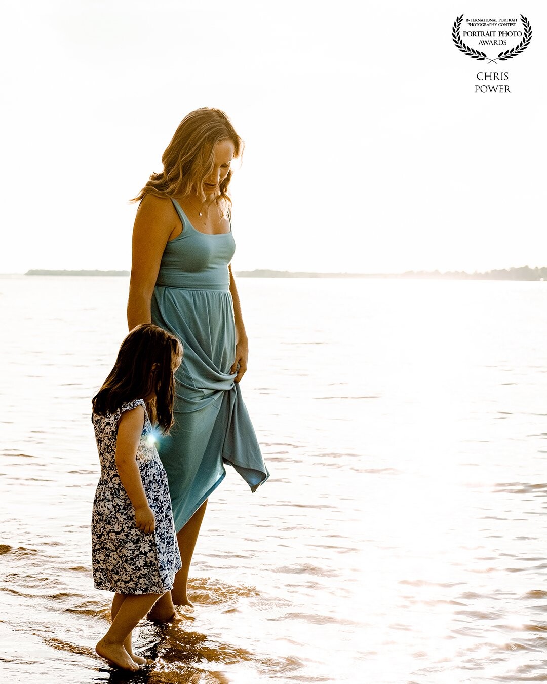 A mother and daughter in the moment walking at the waters edge. The start of a lifelong journey together, supporting each other and challenging each other to grow.