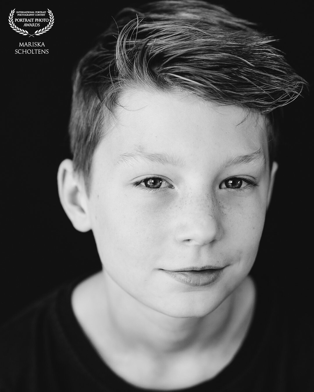 I used only natural daylight and a black background for this portrait. It was litteraly the first photo of the photoshoot of this eleven year old boy!