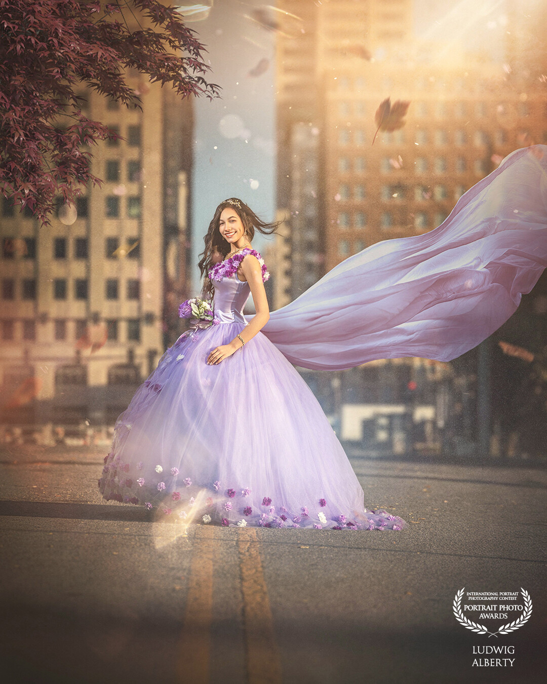 The image showcases a young woman in an enchanting lavender gown adorned with delicate floral embellishments, standing in the middle of an urban street. Her flowing dress and cape billow dramatically, giving the scene a magical, fairy-tale quality. The warm, golden sunlight filters through the cityscape, illuminating her joyful expression as she holds a small bouquet of flowers. Leaves and petals swirl around her, adding to the whimsical atmosphere. The juxtaposition of her elegant, princess-like presence against the modern city buildings creates a striking contrast, blending fantasy with reality.