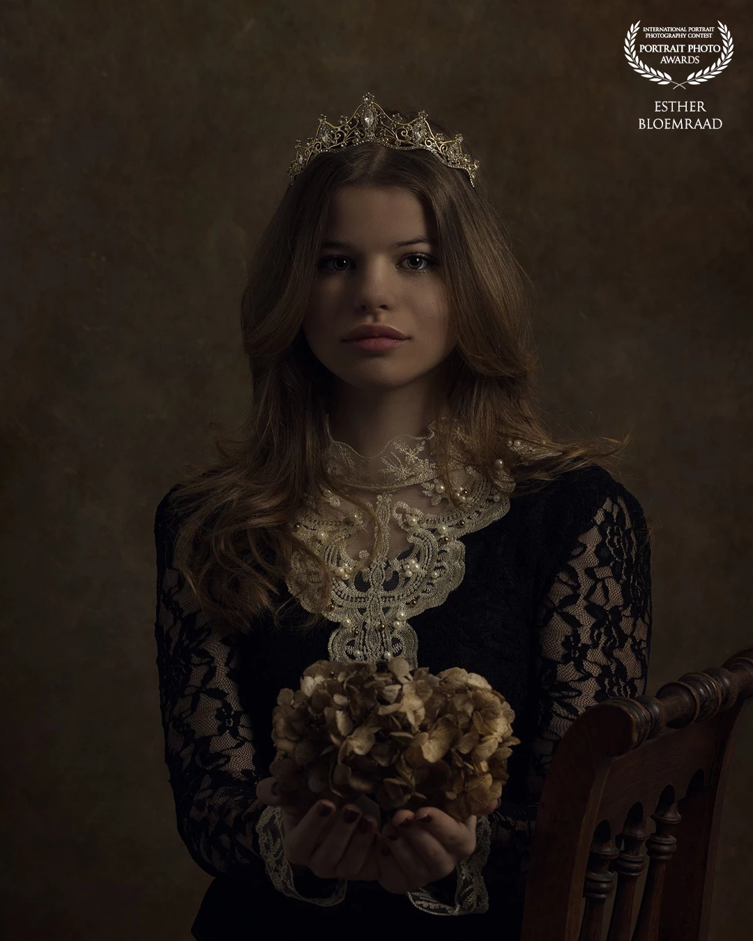For the shoot with Lieke, I used dried hydrangea flowers from my garden. Tiny spiders emerged from the flowers, which she didn’t particularly enjoy, yet she kept her gaze beautifully steady in front of the camera. With the elegant crown on her head, the result is a regal portrait.<br />
<br />
Model: Lieke<br />
Photo & edit: @estherbloemraad.fotografie