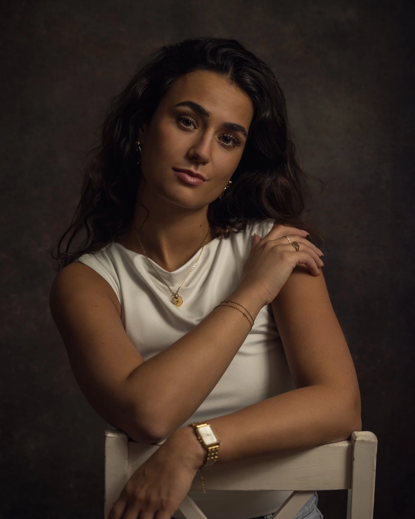 With her stylish look, a touch of gold, and a warm, confident gaze, this portrait radiates both eleg...