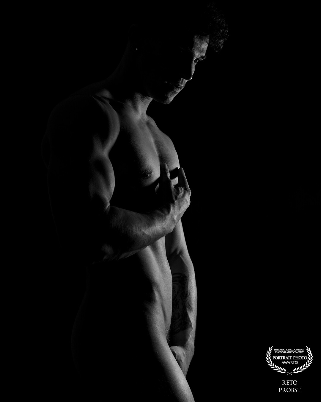 In this high-contrast black and white image, light and darkness merge into a sensual composition. The person emerges from the shadows and casts mysterious silhouettes through the backlight.